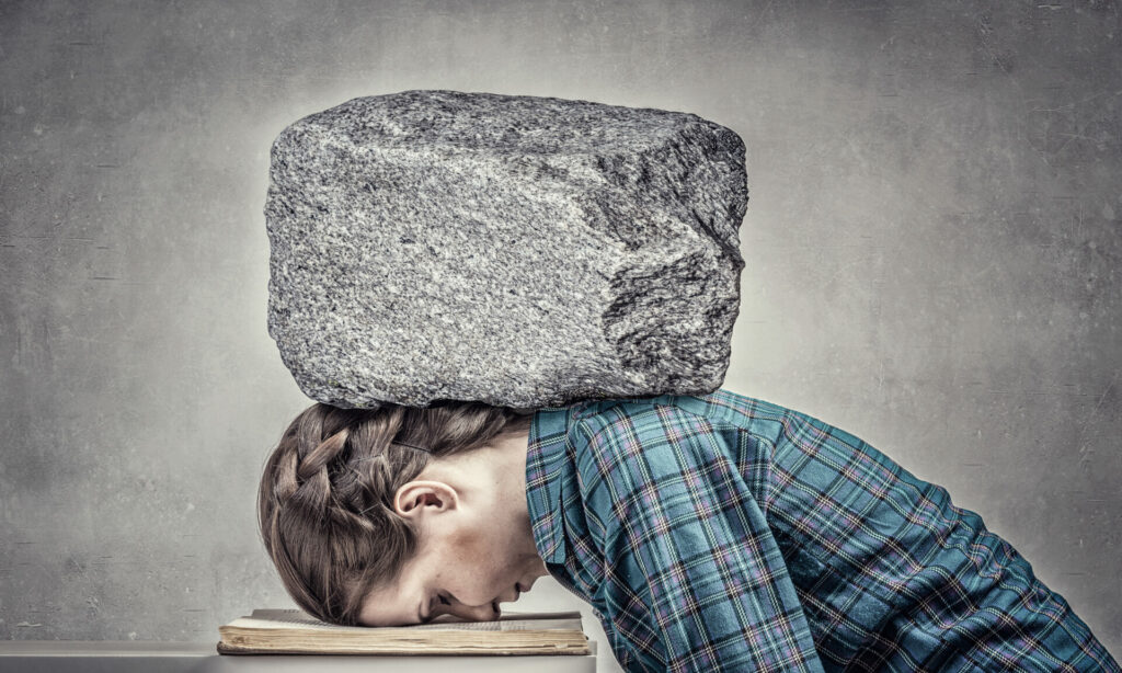 Person bent forward with large stone block balanced on their head and shoulders