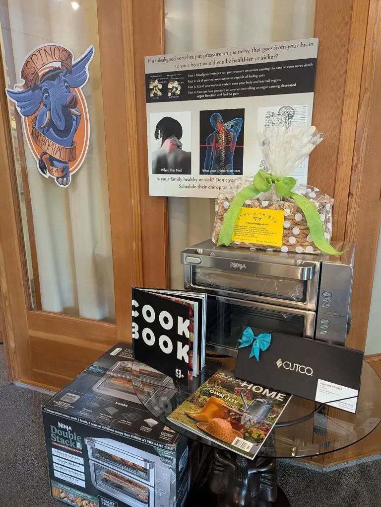 The elephant logo on the office wall above the 25th-anniversary raffle prizes: a toaster oven, knives and cookbooks